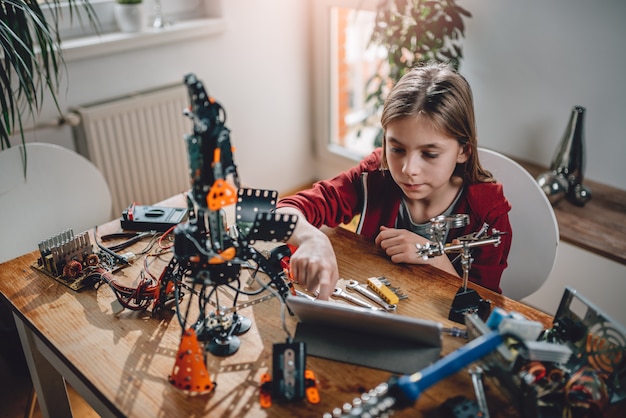 Chica construyendo un robot en casa