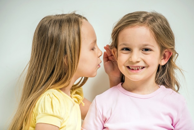 Chica contando un secreto a su amiga