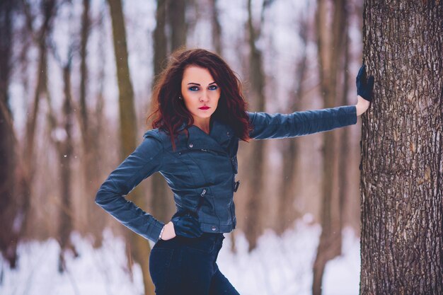 Chica contra el fondo del bosque de invierno