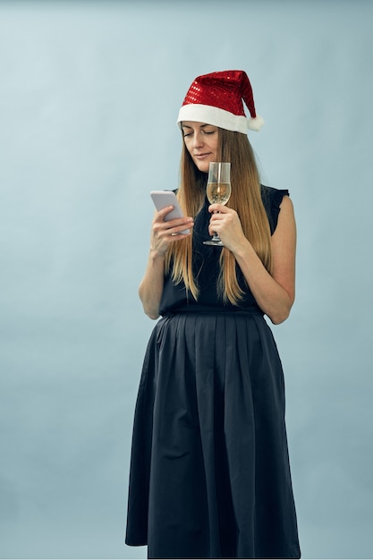 Chica con una copa de champán y un sombrero de santa claus