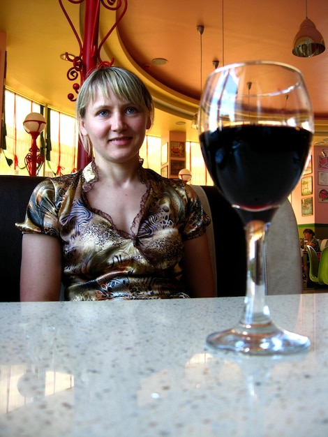 La chica con una copa de vino rojo en el restaurante