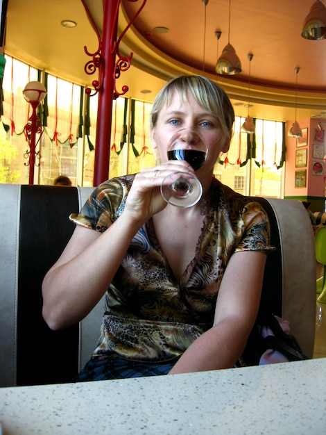 La chica con una copa de vino rojo en el restaurante