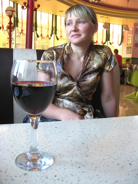 La chica con una copa de vino tinto en el restaurante.