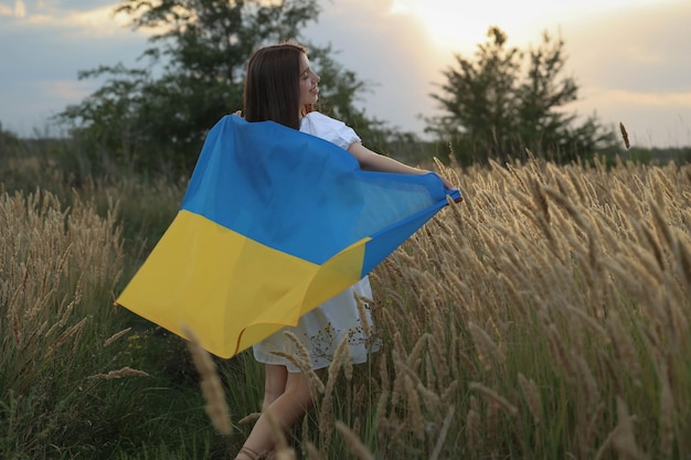 chica corre al sol con la bandera de Ucrania