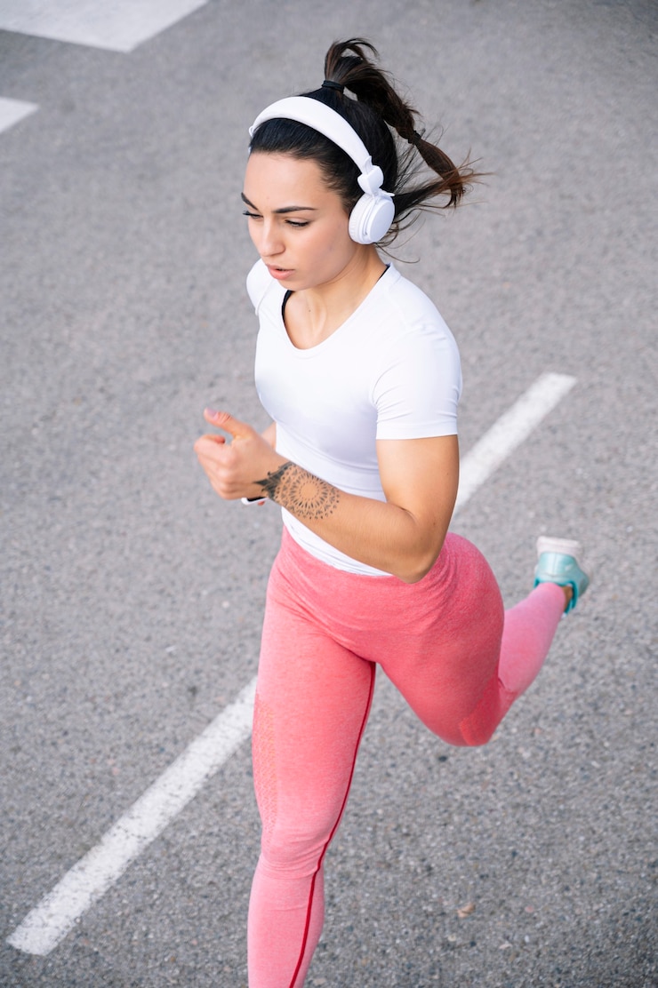 Foto chica corriendo en la calle con auriculares