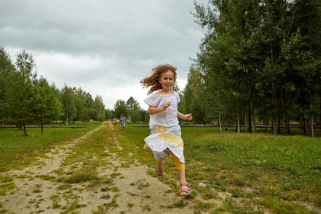 Chica corriendo en el camino en el campo en la naturaleza