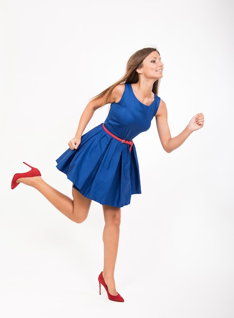 Chica corriendo en vestido azul estudio retrato de longitud completa