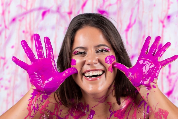 Chica cubierta de pintura rosa divirtiéndose y siendo libre, en un concepto que ayuda contra la conciencia del cáncer de mama y la liberación de la mujer.