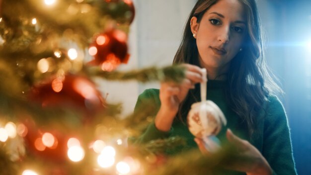 Foto la chica cuelga bolas en el árbol de navidad