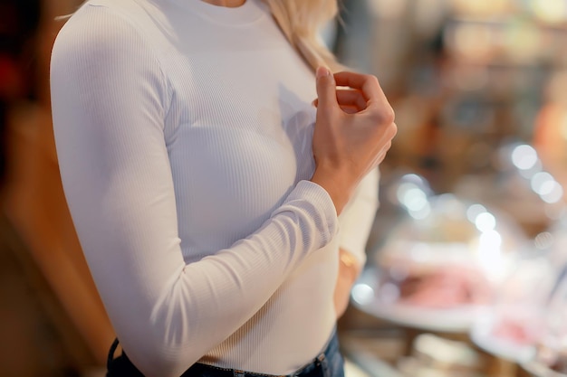 chica con cuello alto de suéter blanco, modelo posando en una tienda de ropa, manga larga de suéter de algodón