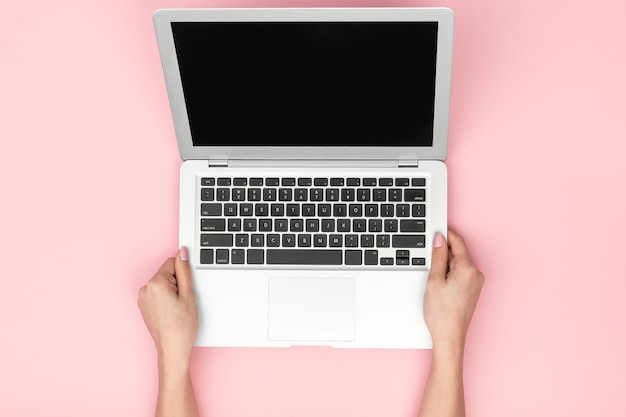 Chica de cultivo con laptop sobre fondo rosa