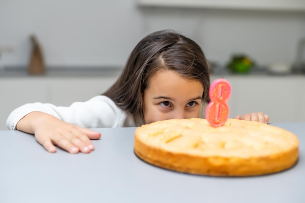 Chica en el cumpleaños con un pastel con vela
