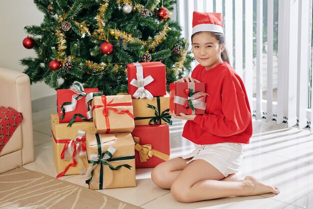 Chica curiosa abriendo regalos