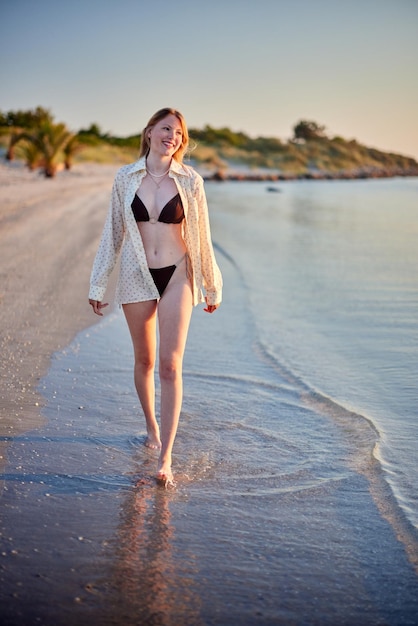 Foto chica danesa caminando por la playa