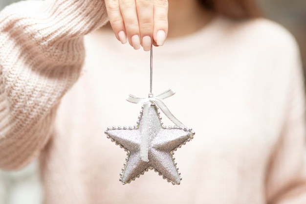 Chica de decoración de abeto de Navidad sosteniendo un juguete de árbol de estrellas