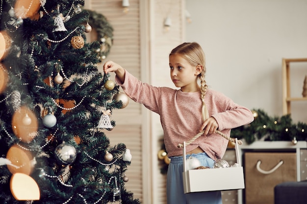 Chica decorando árboles para vacaciones