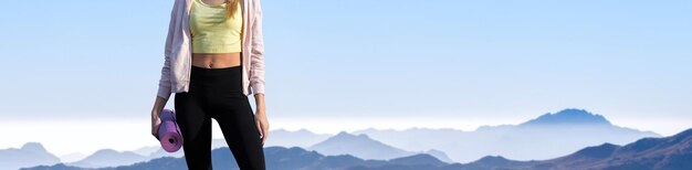 Una chica delgada y atlética se toma un descanso entre clases en el fondo de las montañas temprano en la mañana disfruta del silencio y la libertad