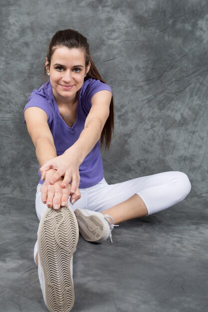 Chica delgada, estirando la pierna para calentar