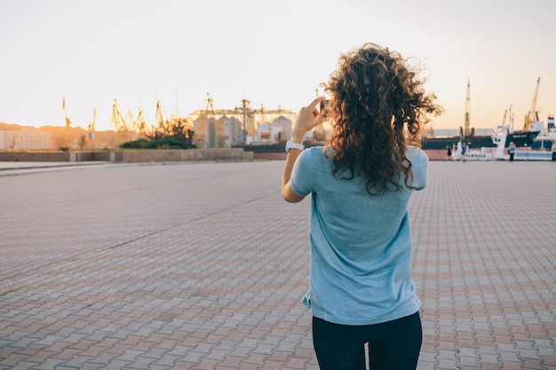 Chica delgada toma fotos del paisaje de la ciudad