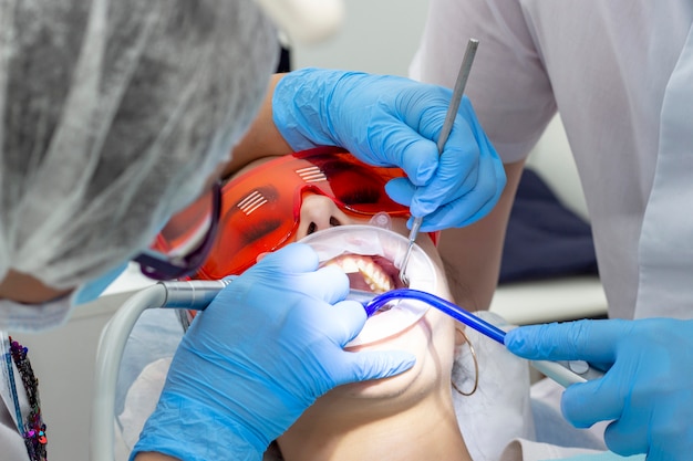 Foto chica en el dentista. tratamiento de dientes cariados.