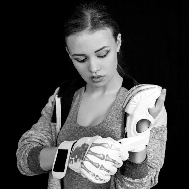 Chica deportista en guantes de boxeo en negro.