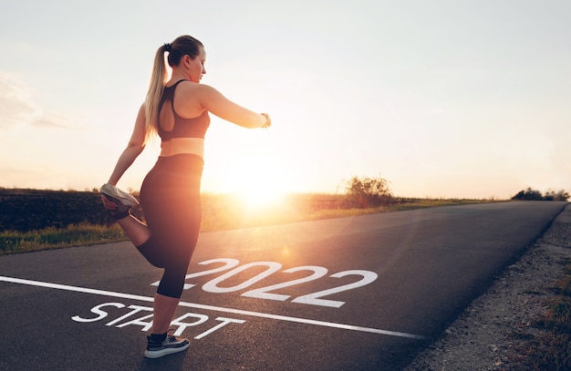 Chica deportiva esperando en la línea de salida para comenzar el año nuevo 2022, nuevos objetivos, planes y visiones