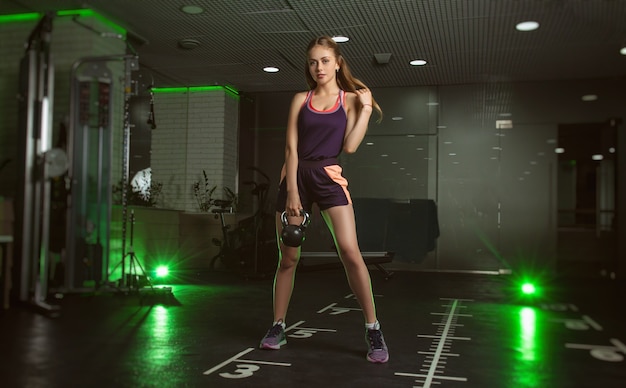 Chica deportiva posando en forma en el gimnasio