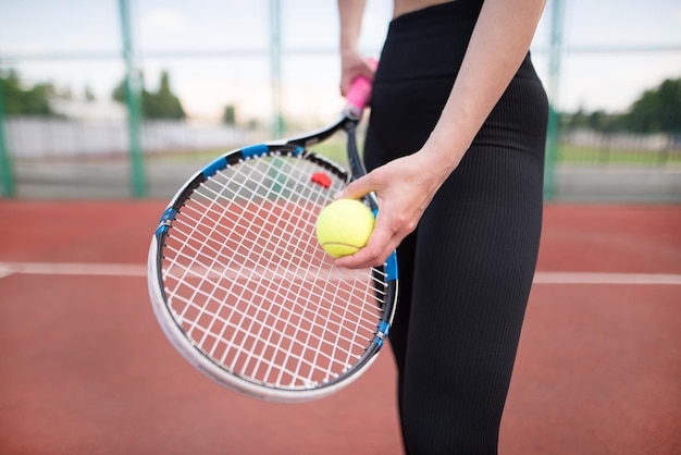 Foto chica deportiva se prepara para servir una pelota de tenis primer plano de una hermosa joven sosteniendo una pelota de tenis y un jugador de tenis de raqueta se está preparando para servir