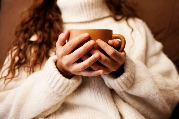 Chica descansando en el sofá con una taza de caféxA