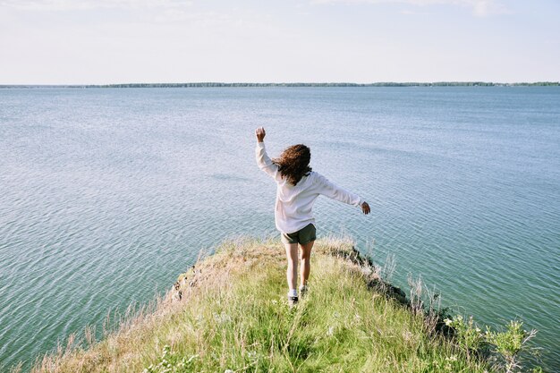 Chica despreocupada corriendo al lago