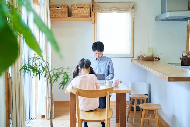 Chica dibujando con su padre trabajando en casa.