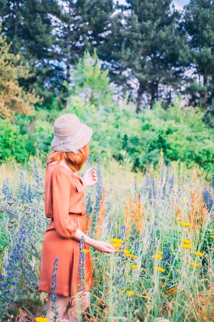 Chica en diente de león en campo verde