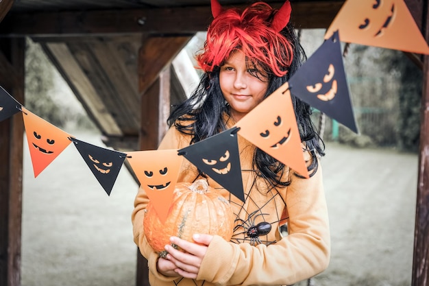 Chica disfrazada de diablo con cuernos rojos en el parque Concepto de Feliz Halloween