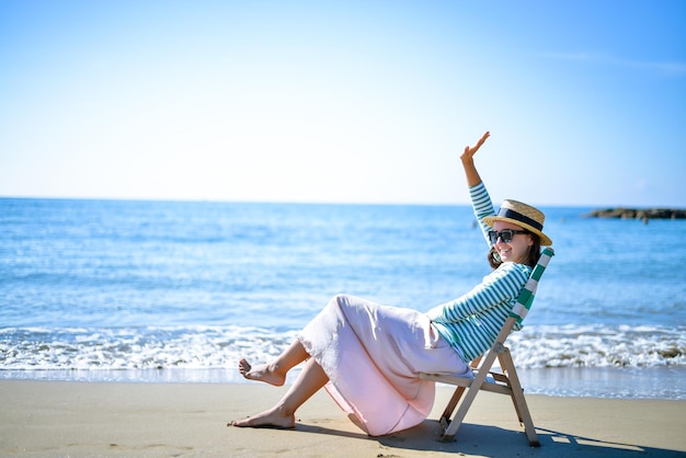 chica disfruta de la puesta de sol junto al mar en una tumbona vintage