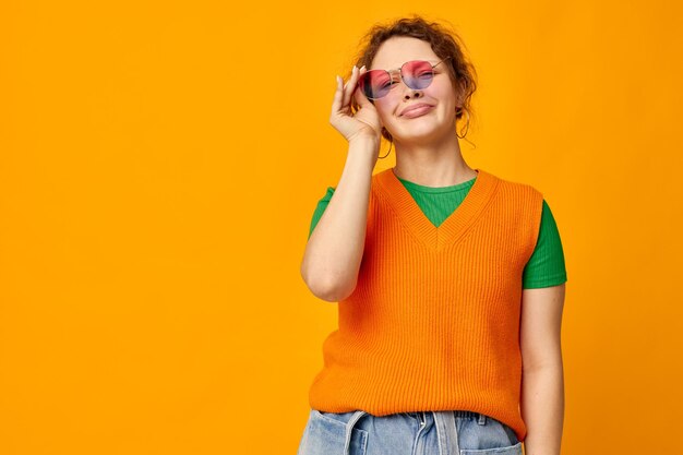 Chica divertida gafas de sol multicolores en la cara posando mueca vista recortada inalterada