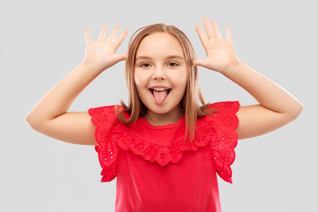 Foto chica divertida mostrando su lengua y haciendo orejas grandes