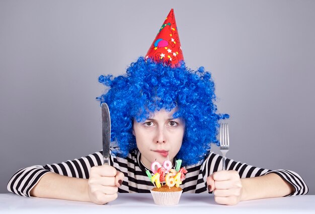 Chica divertida de pelo azul con pastel.