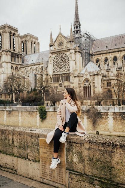 chica divirtiéndose cerca de la catedral de Notre-Dame en París, Francia.