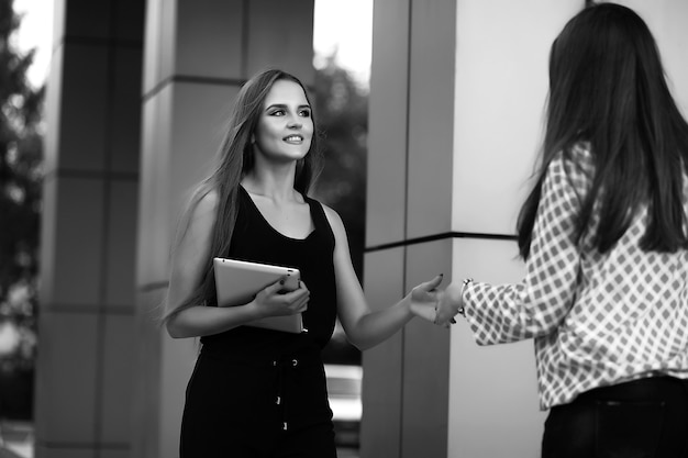 Chica con documentos en una reunión de negocios cerca de un edificio moderno