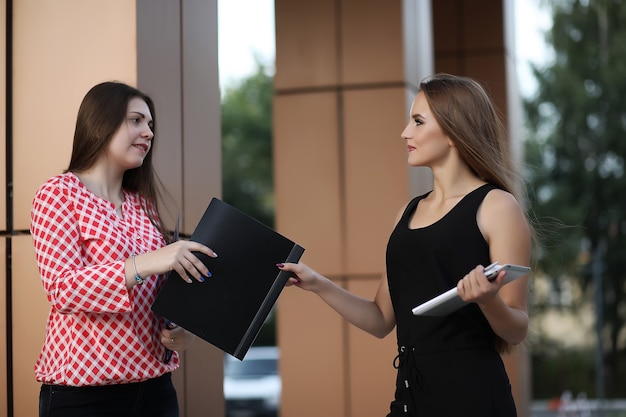 Chica con documentos en una reunión de negocios cerca de un edificio moderno