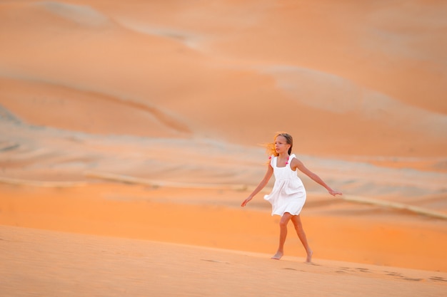 Chica entre las dunas en el desierto en Emiratos Árabes Unidos.