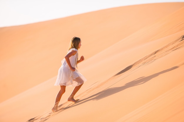 Chica entre las dunas en el desierto en Emiratos Árabes Unidos.