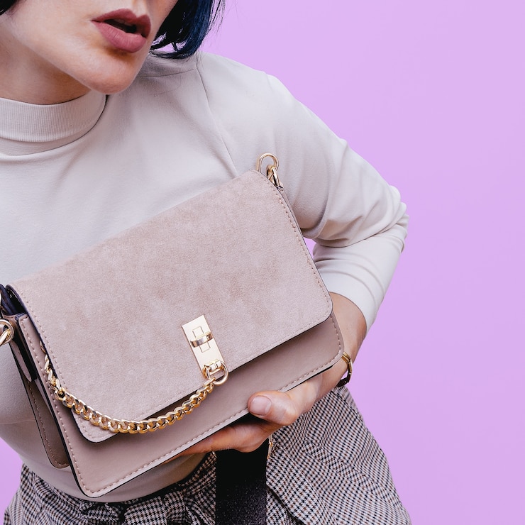Foto chica con un elegante bolso de mano beige. accesorio de mujer