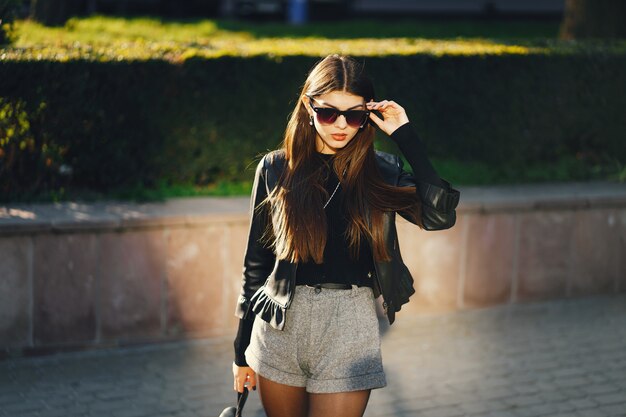 Foto chica elegante caminando por la ciudad en un cálido y soleado día de otoño