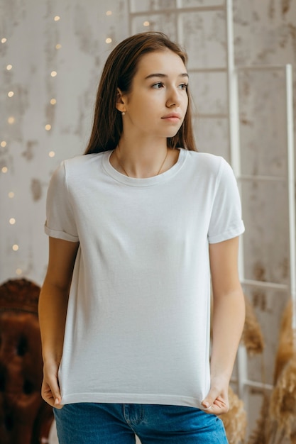 Chica elegante con camiseta blanca posando en estudio
