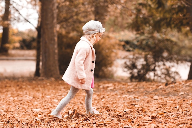 Chica elegante niño caminando en el parque