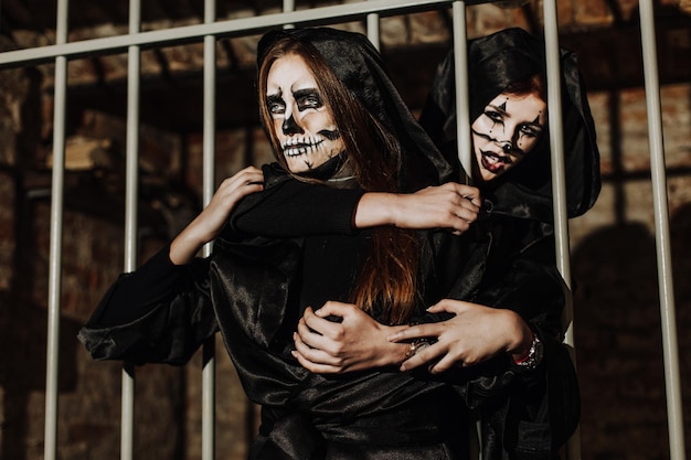 Una chica con elegante sombrero de copa con maquillaje de calavera y tatuaje en el brazo Fiesta de Halloween