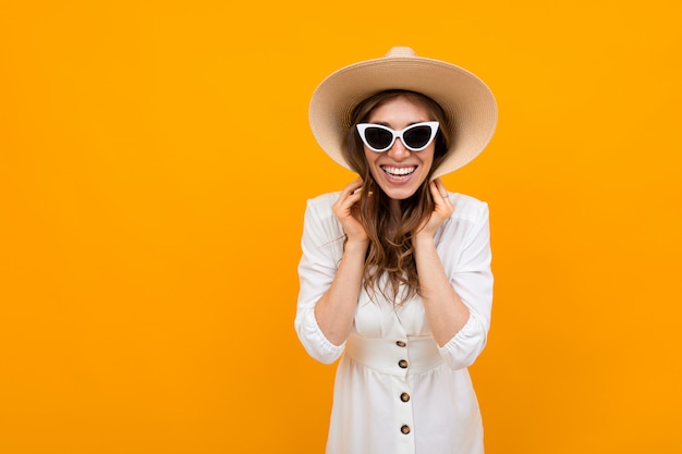 Chica elegante sonríe y sostiene sombreros de campo con las manos