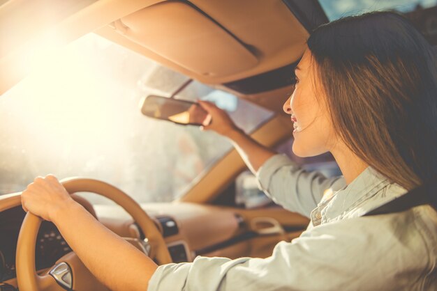 chica elegante tocando un espejo retrovisor