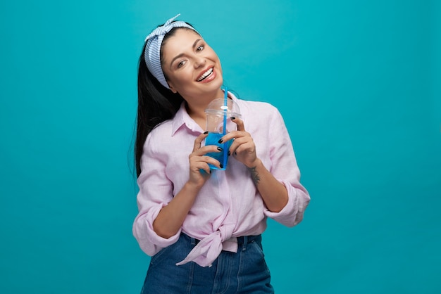 Chica elegante con vaso de plástico con bebida gaseosa.